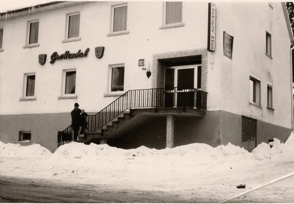 Schwarzweißaufnahme im Winter: das Gasthaus mit dem Schriftzug Grottental, davor hohe Schneewälle