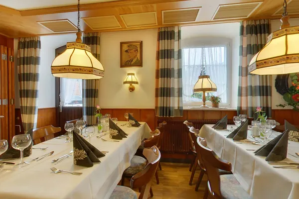 Nebenstube mit Holzvertäfelung, Hängelampen und gedeckten Tafeln