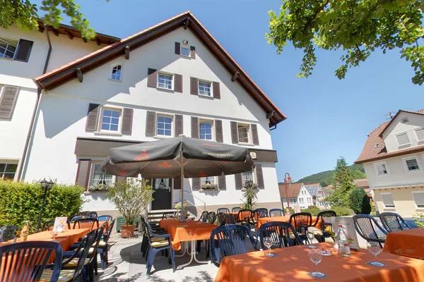Der Biergarten mit Sonnenschirmen vor dem Haus
