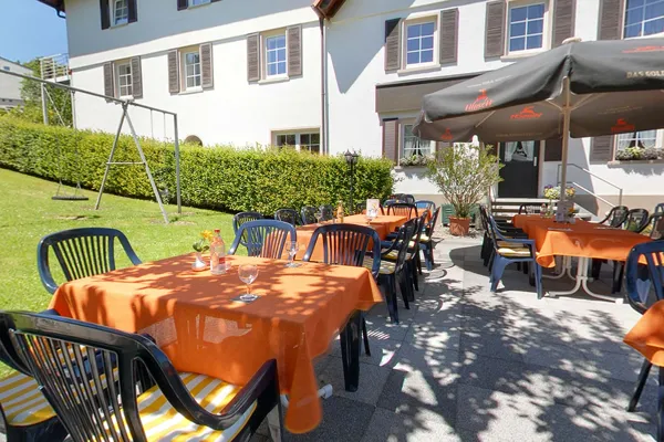 Tische mit orangefarbenen Decken im Biergarten
