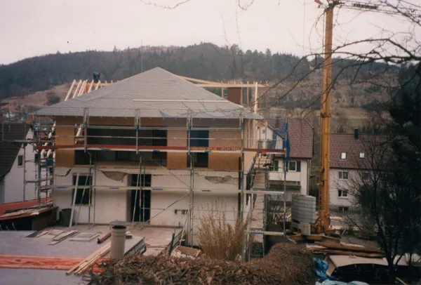 Das Haus im Gerüst, der neue Dachstuhl aus Holz ist aufgesetzt