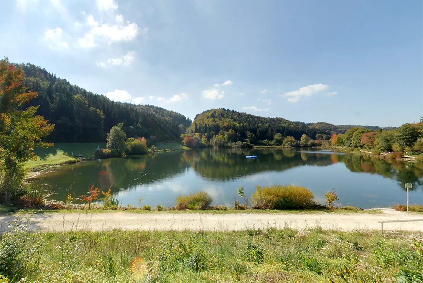 Der Stausee Oberdigisheim zwischen bewaldeten Hängen im Herbst