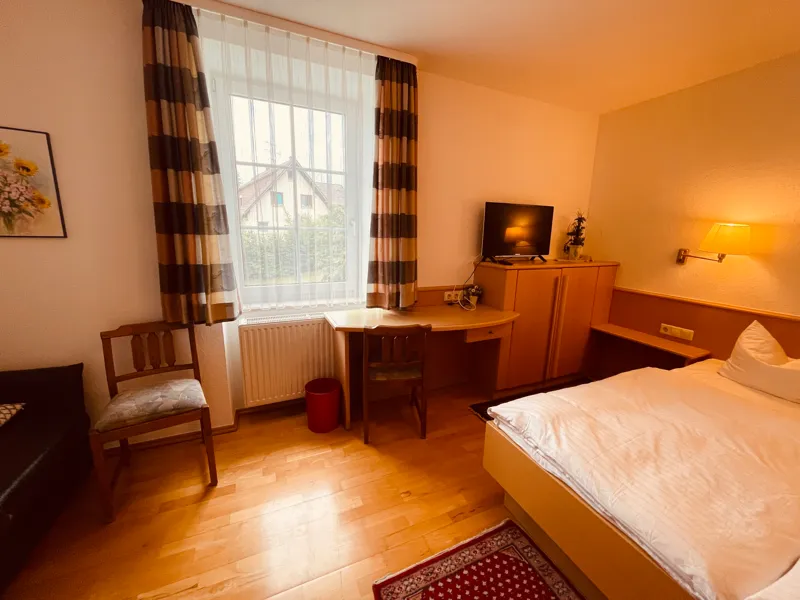 Doppelzimmer mit Sitzecke, Schreibtisch und Fenster